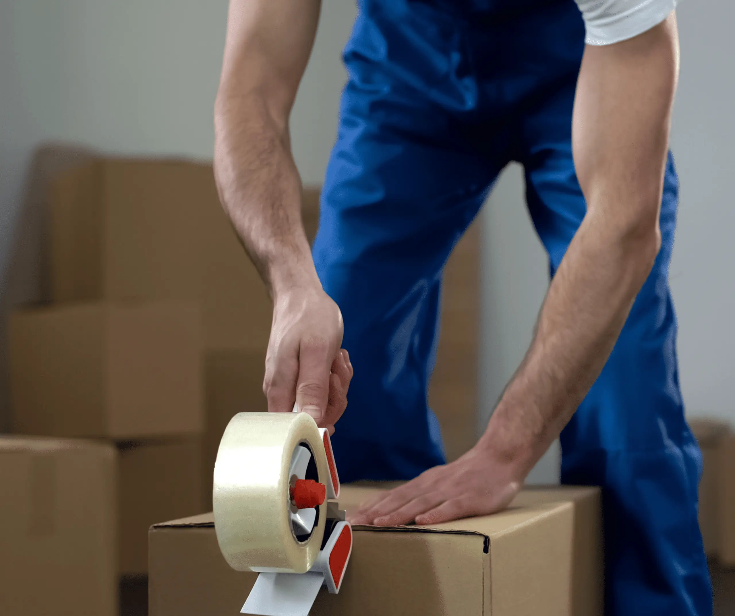 A man closing a box with tape